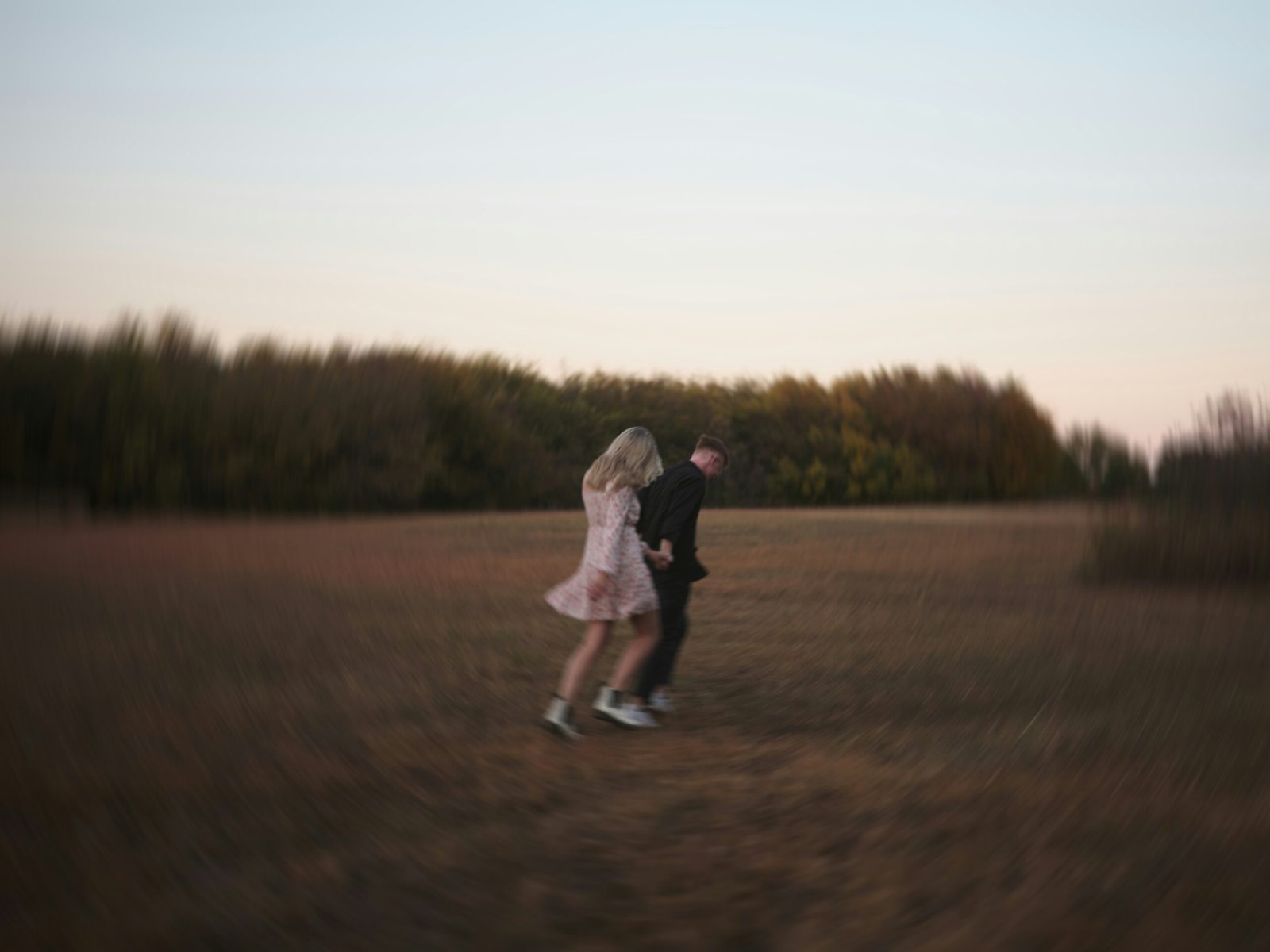 A couple runs across a field.